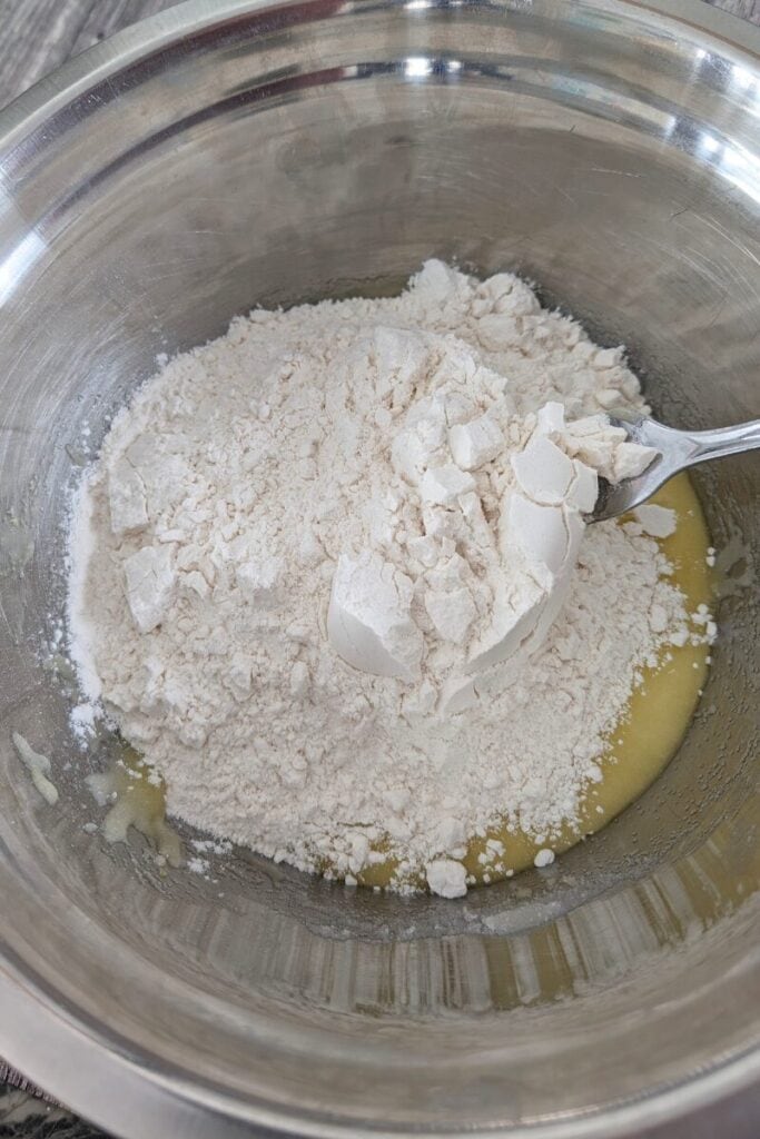 adding dry ingredients into the sugar oil egg mixture