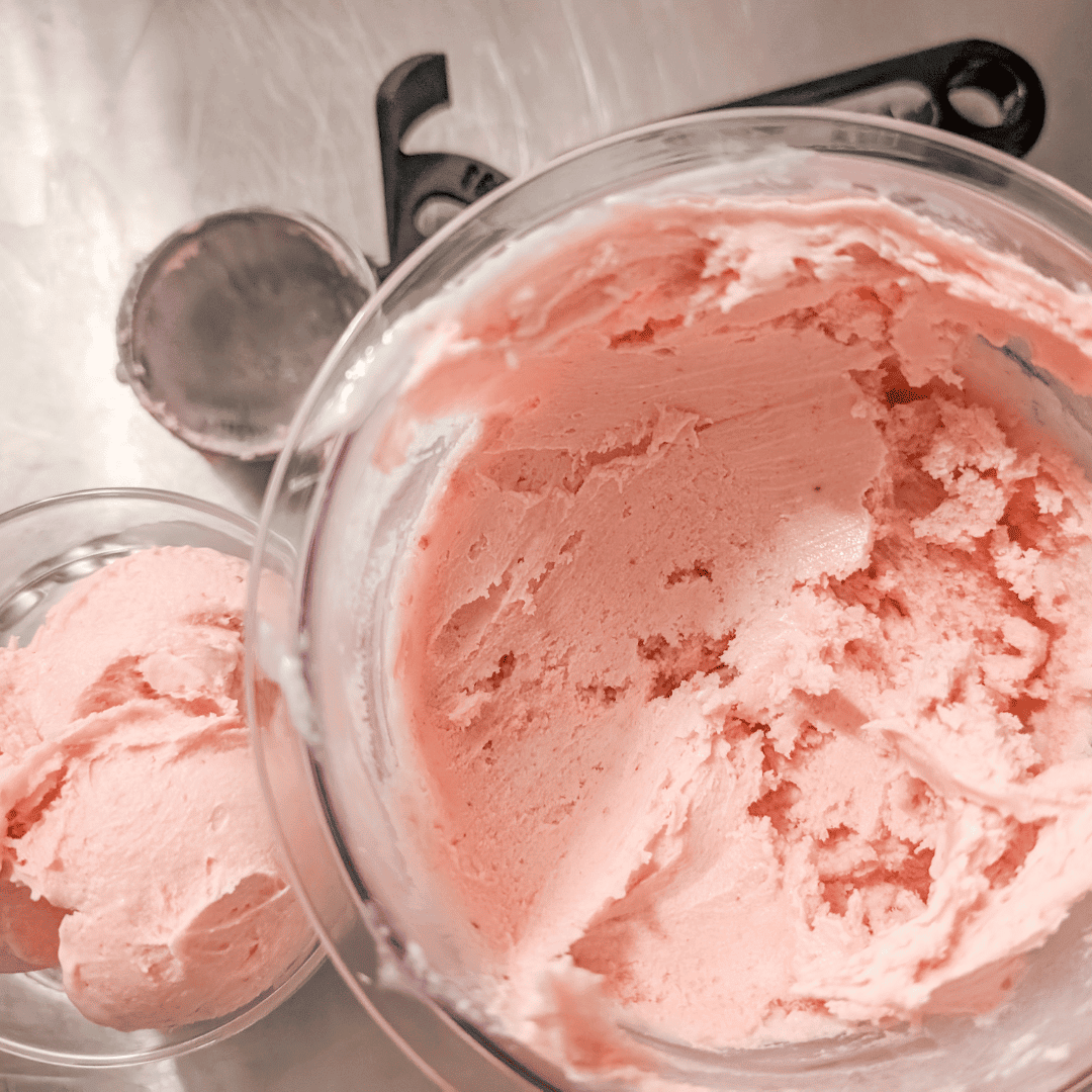 Delicious homemade strawberry ice cream in a glass bowl, perfect for summer desserts and sweet treat.