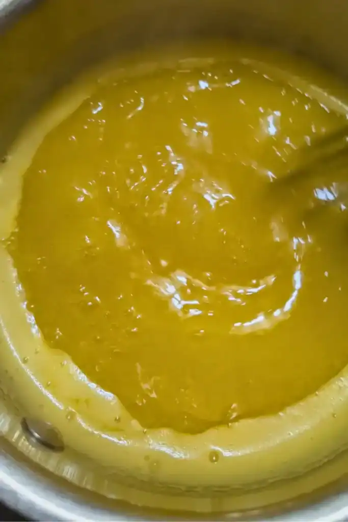 reducing orange sauce in saucepan on medium high heat