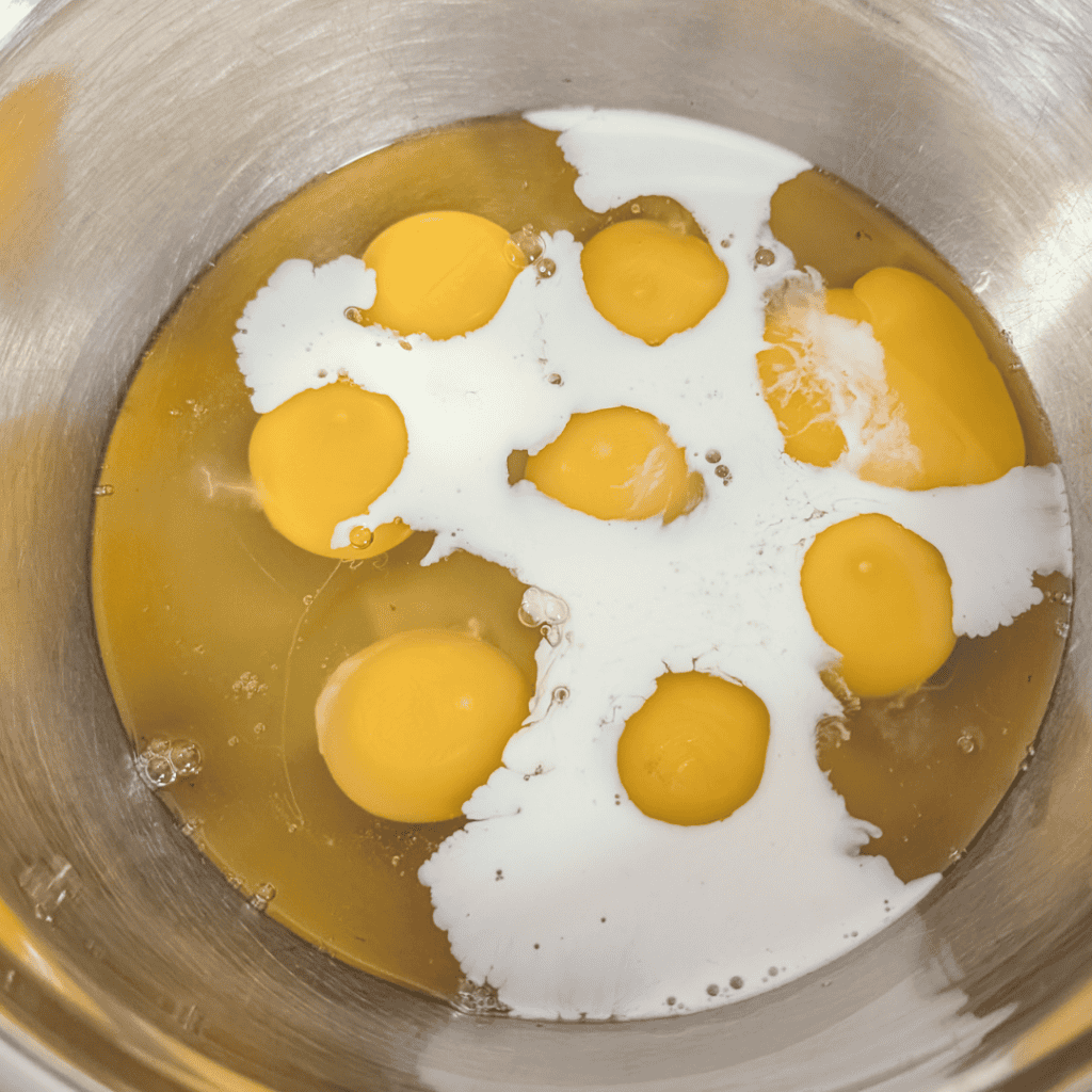 Eggs for sausage frittata with baby spinach, ready to be whisked for cooking.