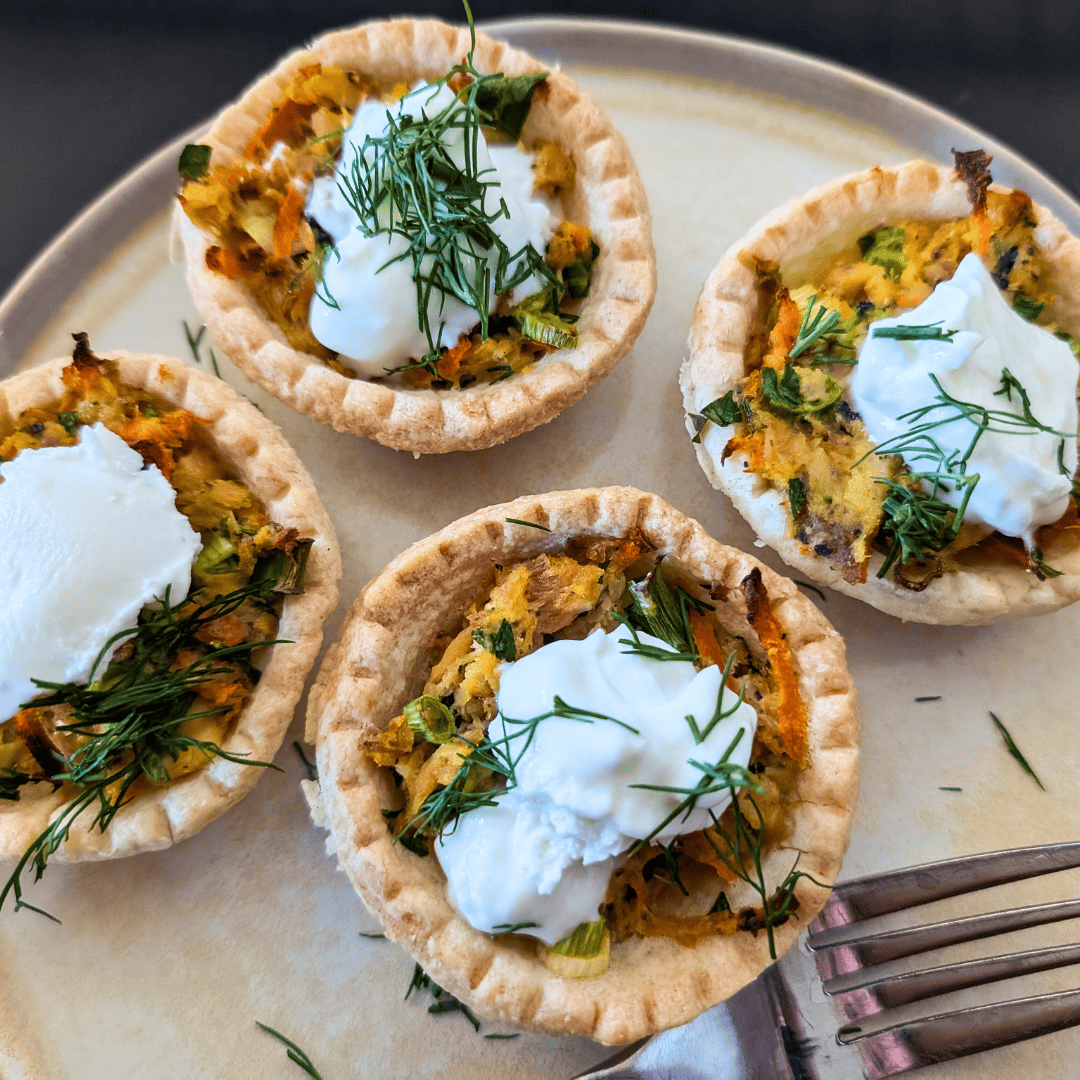 canned salmon tartlets on beige round plate with fork