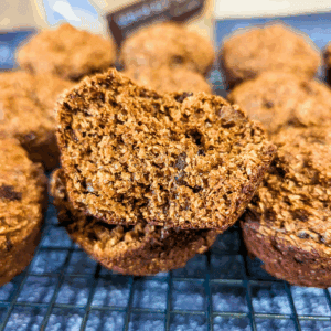 raisin bran muffins on wire rack one cut open to view inside