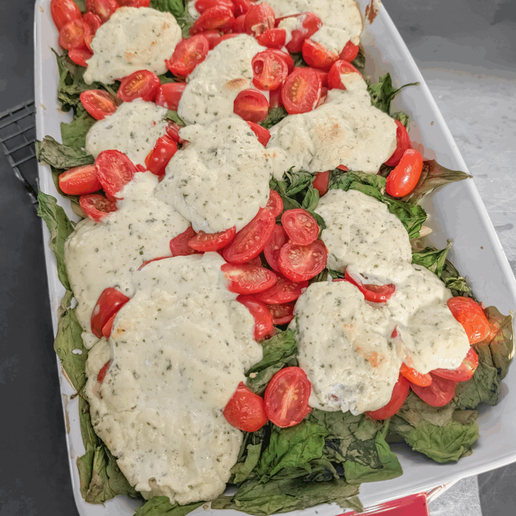 Fresh Caprese Salad with Cherry Tomatoes and Mozzarella Cheese, topped with basil and drizzled with balsamic glaze.