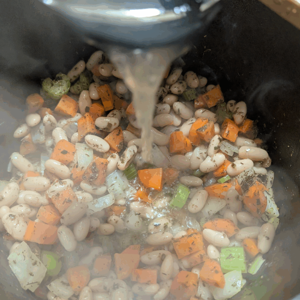 Beans cooking in a pressure cooker with vegetables, making a healthy, budget-friendly meal.