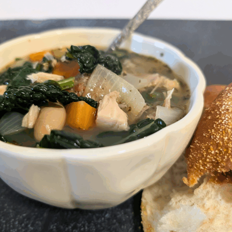 Canned vegetable soup with chicken and bread on a dark background.