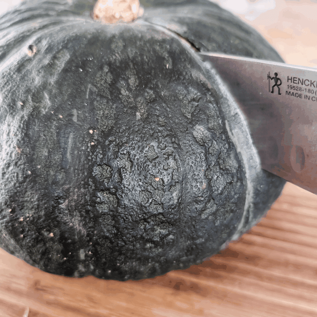 Close-up of a charred bamboo surface with a chef's knife, emphasizing sustainable cooking tools.