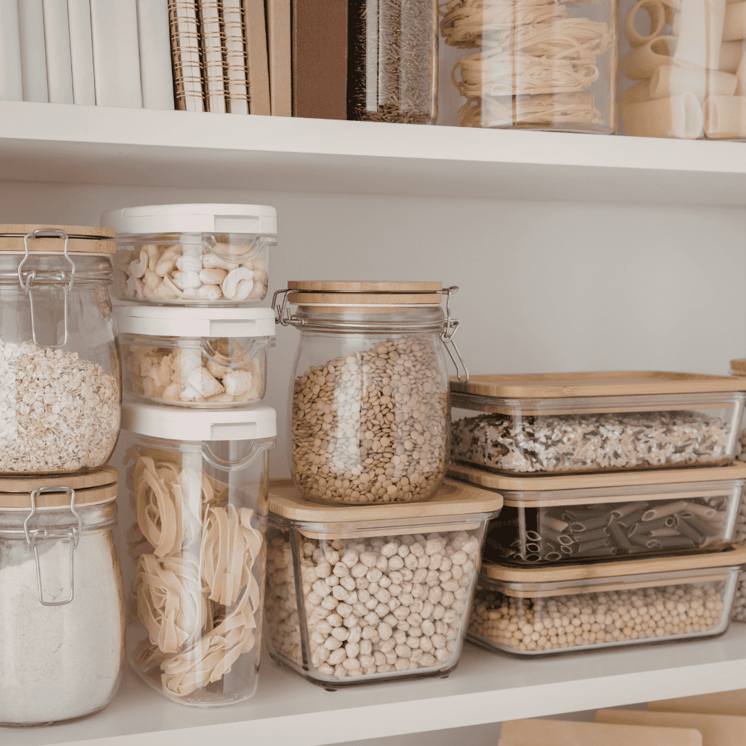 Pantry with glass jars filled with grains, pasta, and legumes for storage.