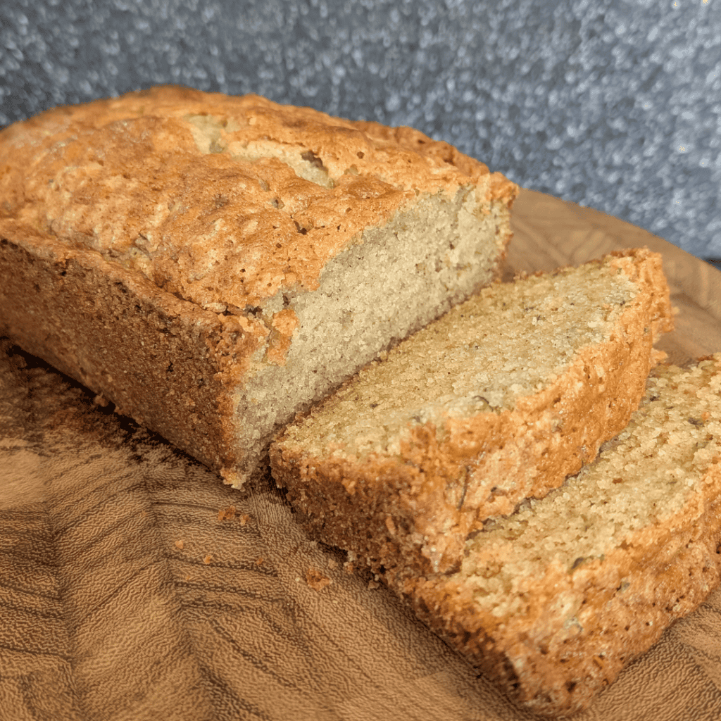 Freshly baked zucchini bread slices on a wooden cutting board.