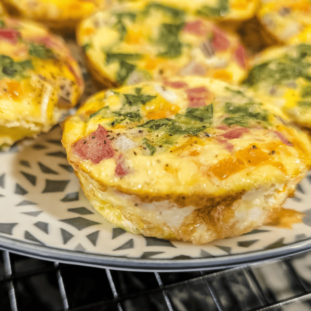 Healthy egg muffins with spinach, bell peppers, ham, and cheese. Perfect for quick, nutritious break.