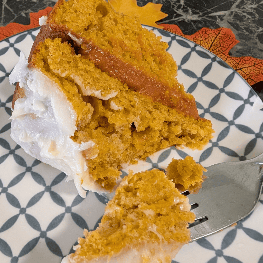 a bit of fluffy pumpkin cake ona fork next to slice