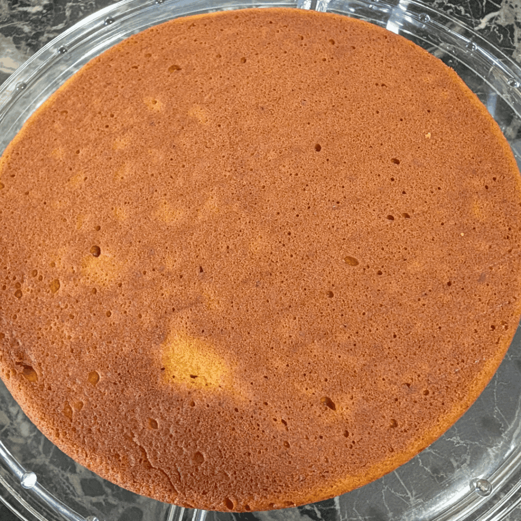 the bottom layer of cake flat side up on cake stand