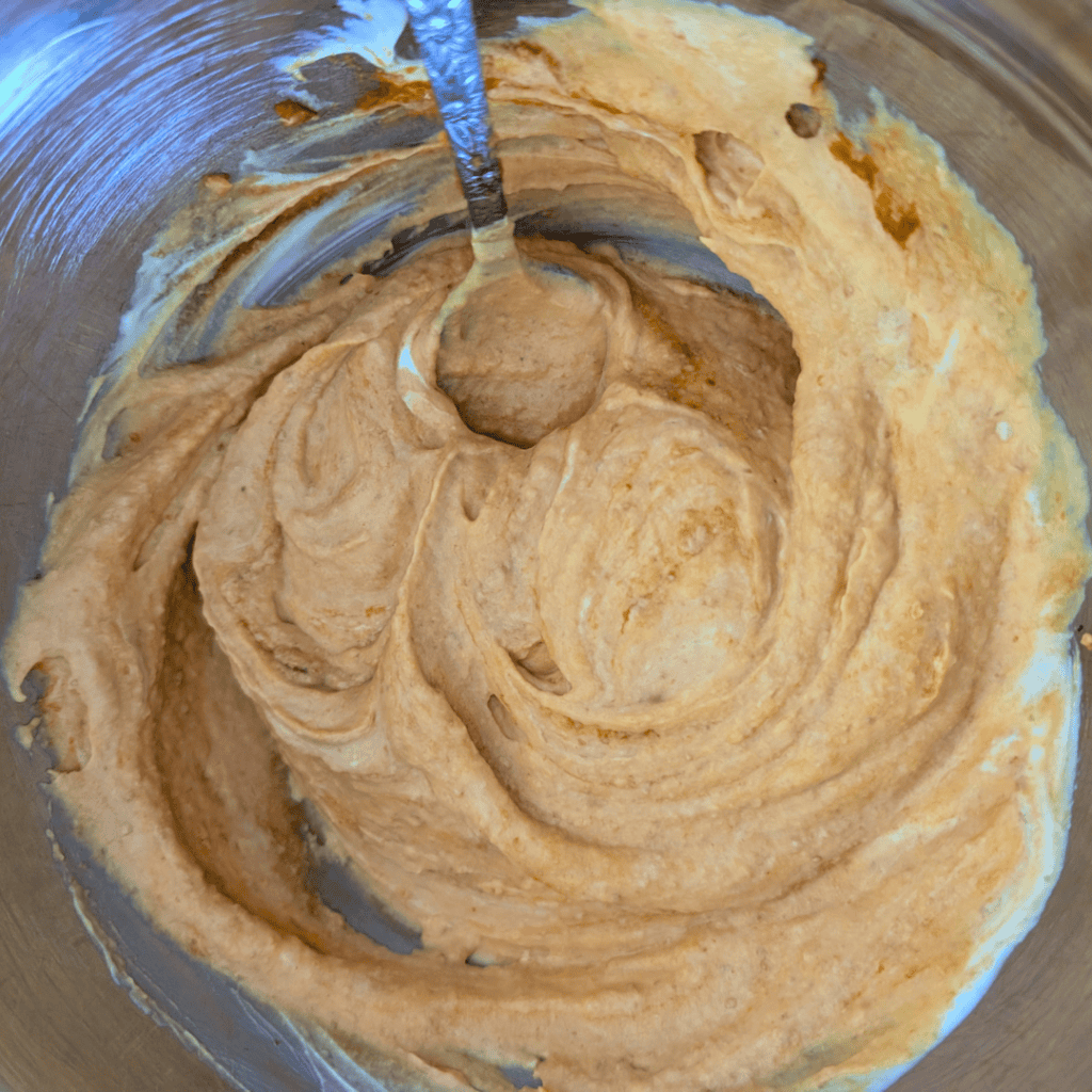 blending the pumpkin puree and greek yogurt for cake batter