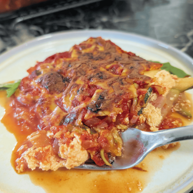 Close-up of homemade eggplant parmesan with melted cheese and tomato sauce.